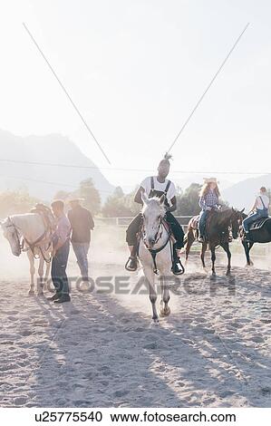Young hipster man with friends riding horses in rural equestrian arena, Primaluna, Trentino-Alto Adige, Italy View Large Photo Image Stock Image - Young hipster man with friends riding horses in rural equestrian arena, Primaluna, Trentino-Alto Adige, Italy. Fotosearch