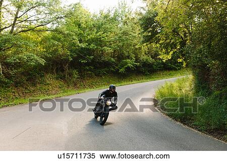 Young male motorcyclist on vintage motorcycle on rural road bend, Florence, Tuscany, Italy View Large Photo Image Stock Photography - Young male motorcyclist on vintage motorcycle on rural road bend, Florence, Tuscany, Italy. Fotosearch