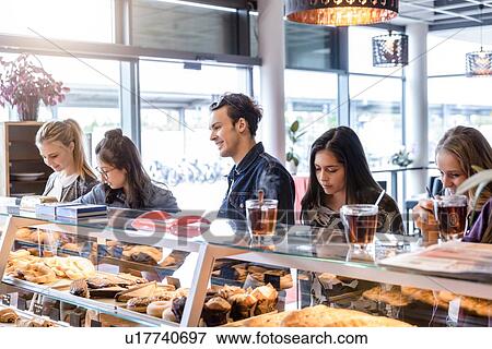 Young male student and female friends queueing at cafe counter View Large Photo Image Stock Photo - Young male student and female friends queueing at cafe counter. Fotosearch