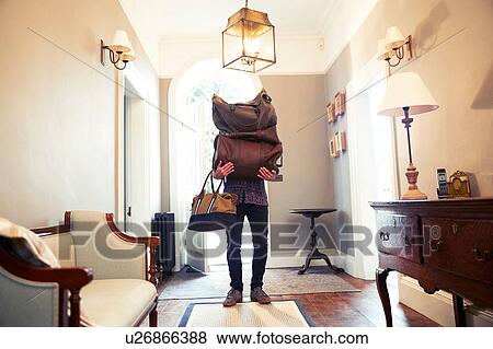 Young man carrying stack of luggage in hotel lobby View Large Photo Image Stock Photo - Young man carrying stack of luggage in hotel lobby. Fotosearch