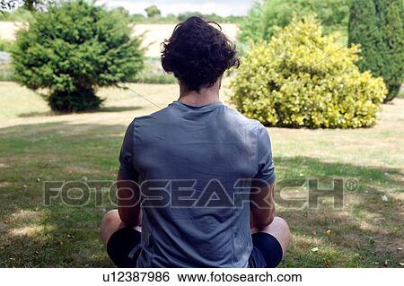 Young man practicing yoga in garden, rear view lotus pose View Large Photo Image Stock Photograph - Young man practicing yoga in garden, rear view lotus pose. Fotosearch