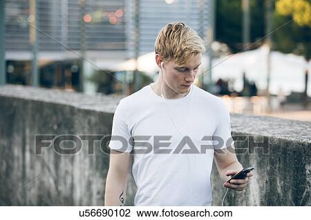 Stock Image - Young man using mobile phone. Fotosearch