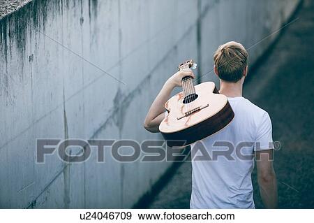 Stock Photo - Young musician with guitar. Fotosearch