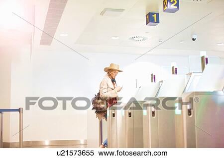 Young woman at airport, walking through turnstile View Large Photo Image Stock Photography - Young woman at airport, walking through turnstile. Fotosearch