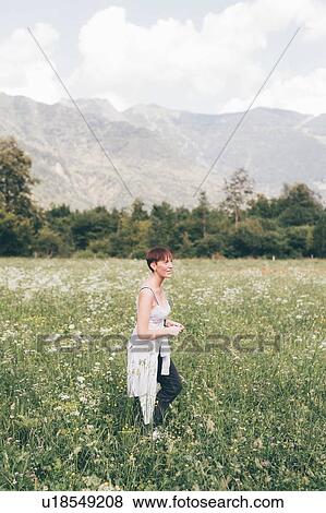 Stock Photo - Young woman in wildflower meadow, Primaluna, Trentino-Alto Adige, Italy. Fotosearch