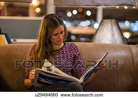 Young woman reading book in office View Large Photo Image Stock Image - Young woman reading book in office. Fotosearch