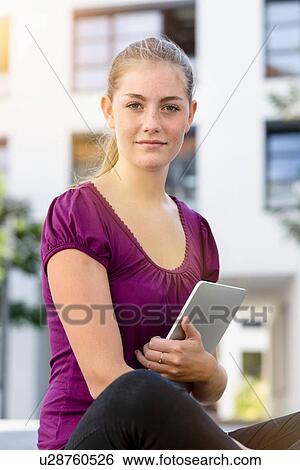 Young woman with digital tablet in park View Large Photo Image Stock Photograph - Young woman with digital tablet in park. Fotosearch
