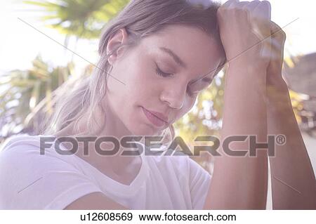 Young woman with eyes closed clasping hands View Large Photo Image Stock Photo - Young woman with eyes closed clasping hands. Fotosearch