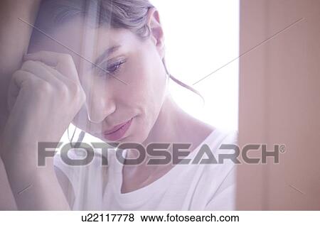 Stock Photo - Young woman with eyes closed clasping hands. Fotosearch