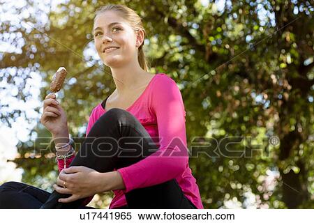 Young woman with ice cream in park View Large Photo Image Stock Photography - Young woman with ice cream in park. Fotosearch