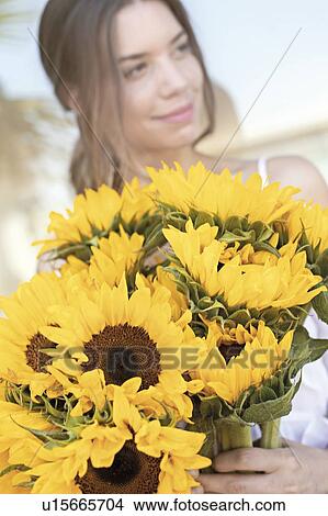 Picture - Young woman with sunflowers. Fotosearch