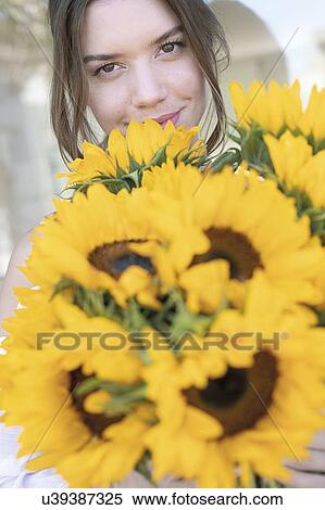 Stock Photography - Young woman with sunflowers. Fotosearch