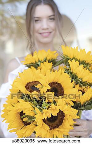 Stock Photography - Young woman with sunflowers. Fotosearch
