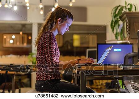 Young woman working late in office View Large Photo Image Stock Image - Young woman working late in office. Fotosearch