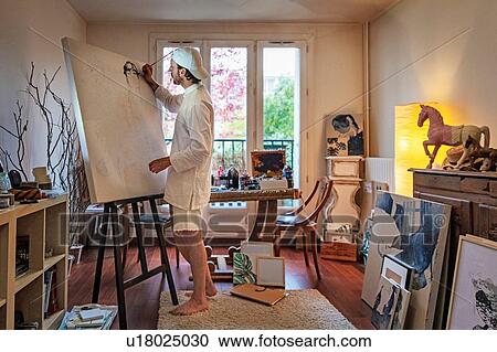 Stock Image - Artist working on canvas in studio. Fotosearch