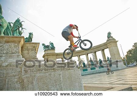 Stock Image - BMX cyclist doing stunt, Heroes Square (Hosk Tere), Budapest, Hungary. Fotosearch
