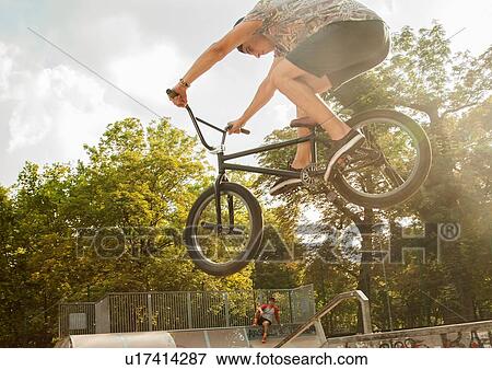 Stock Photo - BMX cyclist doing stunt on ramp. Fotosearch