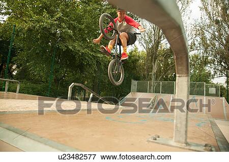 BMX cyclist doing stunt on ramp View Large Photo Image Stock Photo - BMX cyclist doing stunt on ramp. Fotosearch