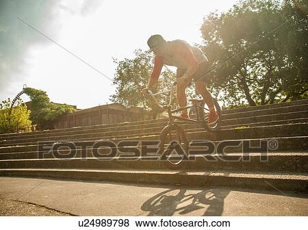 BMX cyclist doing stunt on steps View Large Photo Image Stock Photo - BMX cyclist doing stunt on steps. Fotosearch