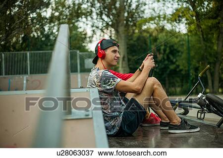 BMX cyclist resting beside ramp View Large Photo Image Stock Photo - BMX cyclist resting beside ramp. Fotosearch