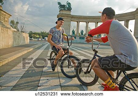 Stock Image - BMX cyclist resting, Heroes Square (Hosk Tere), Budapest, Hungary. Fotosearch