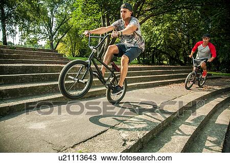 BMX cyclists doing wheelie on steps View Large Photo Image Stock Image - BMX cyclists doing wheelie on steps. Fotosearch