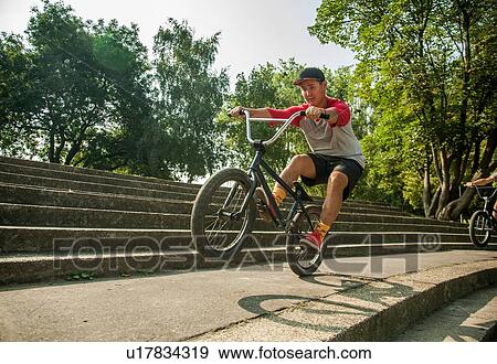 BMX cyclists doing wheelie on steps View Large Photo Image Stock Photo - BMX cyclists doing wheelie on steps. Fotosearch