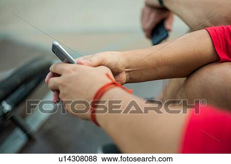 Stock Photo - BMX cyclists resting beside ramp. Fotosearch