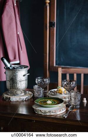 Picture - Bowl of fresh garnished soup, a dessert and champagne on vintage table. Fotosearch