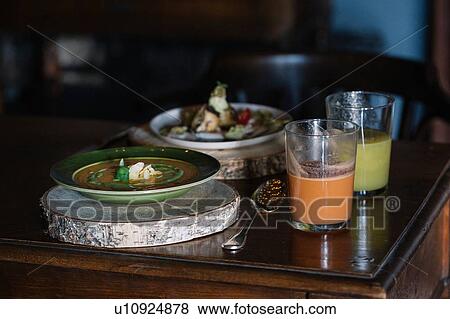 Stock Photo - Bowl of fresh soup and smoothies on rustic table. Fotosearch