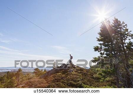 Boy and father looking out from woodland hill over landscape, Aure, More og Romsdal, Norway View Large Photo Image Picture - Boy and father looking out from woodland hill over landscape, Aure, More og Romsdal, Norway. Fotosearch