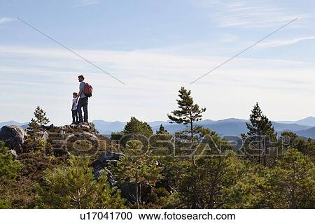 Boy and father looking out from woodland hill over landscape, Aure, More og Romsdal, Norway View Large Photo Image Stock Image - Boy and father looking out from woodland hill over landscape, Aure, More og Romsdal, Norway. Fotosearch