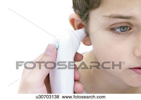 Stock Photo - Boy having his temperature taken with a digital thermometer.. Fotosearch