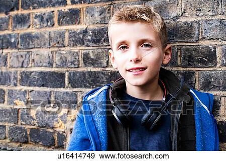 Boy leaning against brickwall View Large Photo Image Stock Photo - Boy leaning against brickwall. Fotosearch