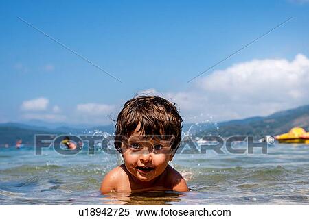 Stock Photography - Boy partially submerged in sea. Fotosearch