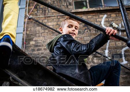 Boy sitting on metal staircase View Large Photo Image Stock Image - Boy sitting on metal staircase. Fotosearch
