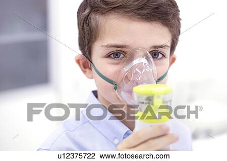 Stock Image - Boy using nebuliser.. Fotosearch