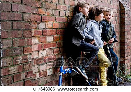 Boys leaning against brickwall View Large Photo Image Stock Photograph - Boys leaning against brickwall. Fotosearch