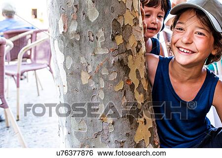Boys playing by tree View Large Photo Image Stock Photograph - Boys playing by tree. Fotosearch