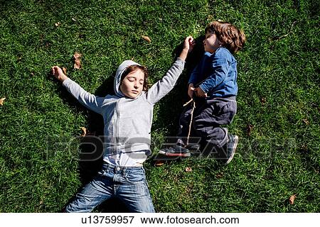 Boys sleeping on grass View Large Photo Image Stock Photo - Boys sleeping on grass. Fotosearch