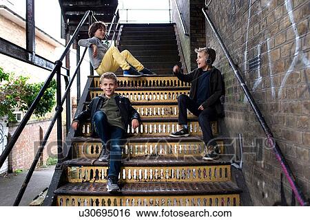 Stock Photograph - Boys talking on metal staircase. Fotosearch