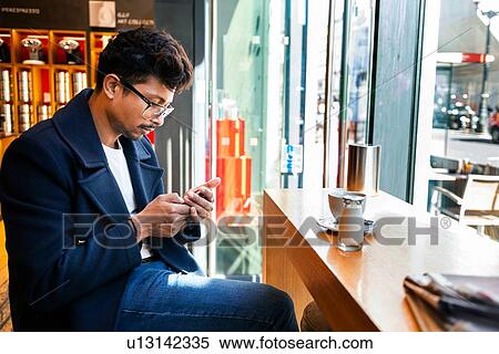 Businessman using smartphone in cafe View Large Photo Image Stock Photography - Businessman using smartphone in cafe. Fotosearch