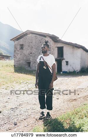 Cool young man in dungarees by farm building, portrait, Primaluna, Trentino-Alto Adige, Italy View Large Photo Image Stock Photo - Cool young man in dungarees by farm building, portrait, Primaluna, Trentino-Alto Adige, Italy. Fotosearch