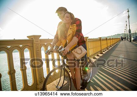 Picture - Couple crossing bridge on bicycle, Budapest, Hungary. Fotosearch