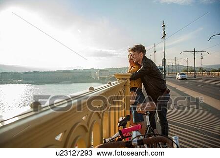 Stock Image - Couple on bridge with bicycles, Budapest, Hungary. Fotosearch