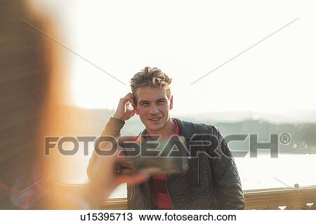 Stock Image - Couple taking photos using smartphone. Fotosearch