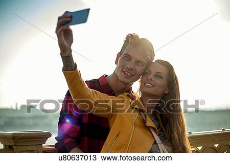 Couple taking selfie on bridge, Budapest, Hungary View Large Photo Image Stock Image - Couple taking selfie on bridge, Budapest, Hungary. Fotosearch