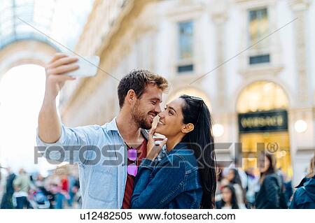 Stock Photography - Couple taking selfie, Piazza del Duomo, Milan, Italy. Fotosearch