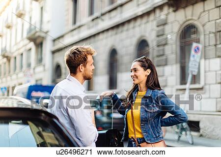 Stock Image - Couple talking in street, Milan, Italy. Fotosearch