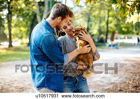 Couple with pet dog in park View Large Photo Image Stock Image - Couple with pet dog in park. Fotosearch